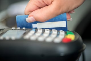 Hand swiping debit card on pos terminal