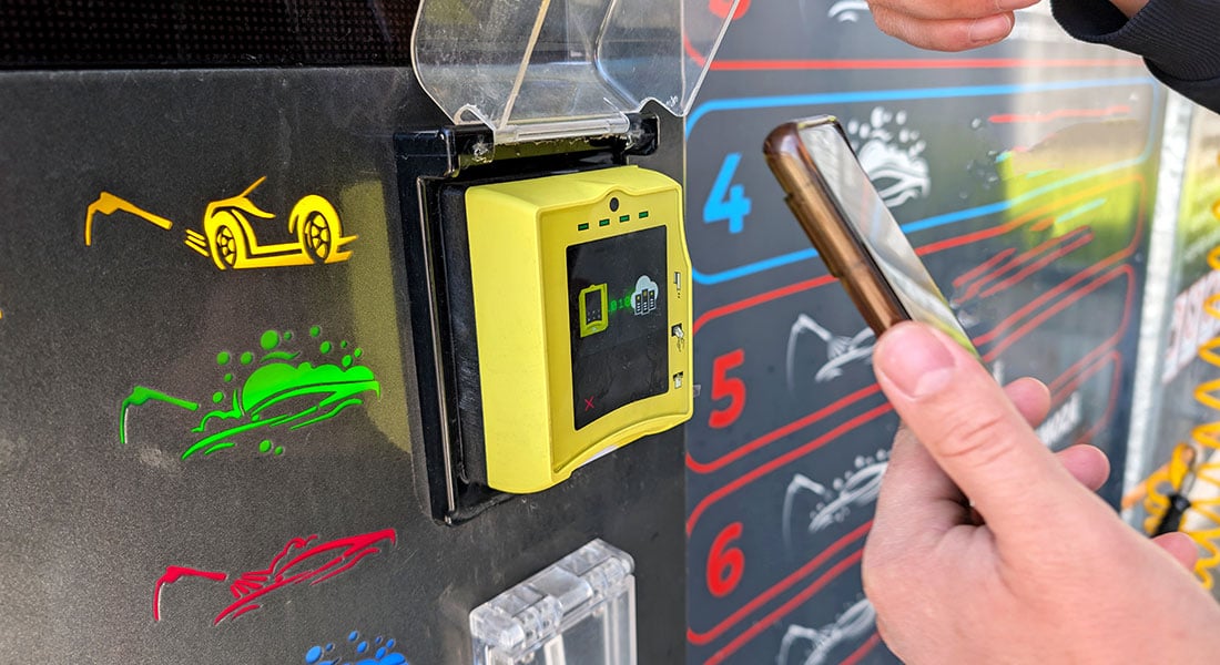 customer making a contactless mobile payment at a self-service car wash