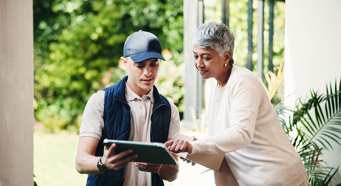 field service technician using a tablet with a customer during an on-site service appointment.